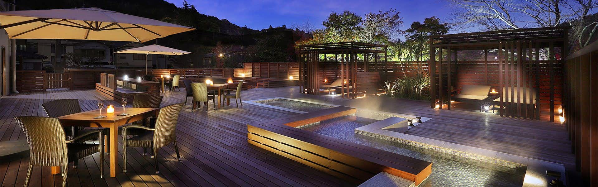 Mizuno Sato Marukyu Ryokan with a landscaped terrace with lit tables and shallow water features.
