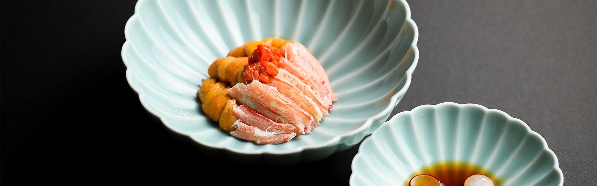 Gion Shinmonso with a delicate crab dish served on pale ceramic plates.