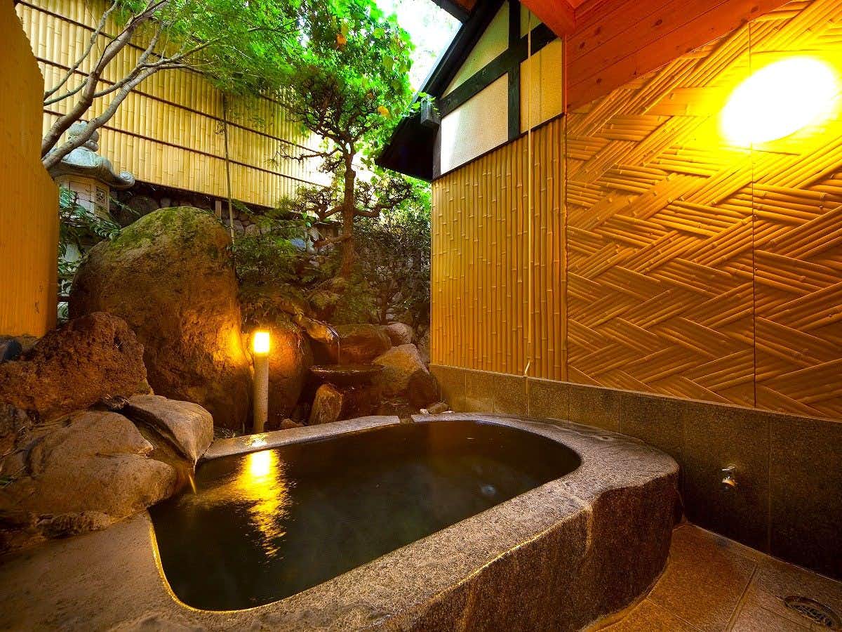 Nagomino Yado Mutsuki with a private stone bath surrounded by garden greenery.