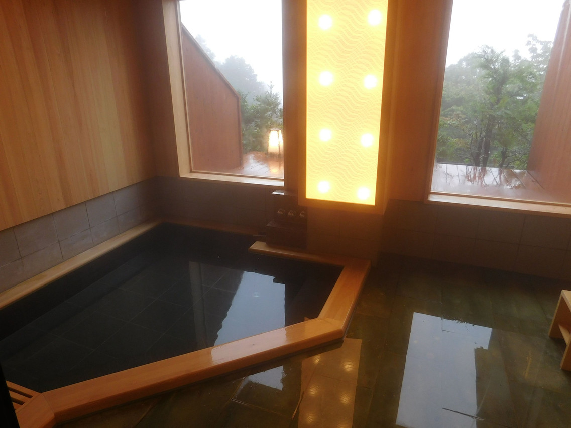 A dark indoor bath with a window.