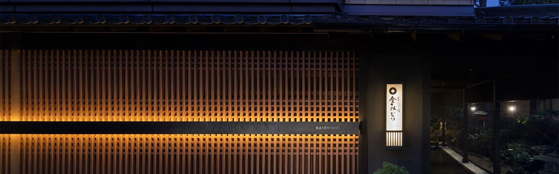 Kanemidori with the main timber facade illuminated beneath the night sky.