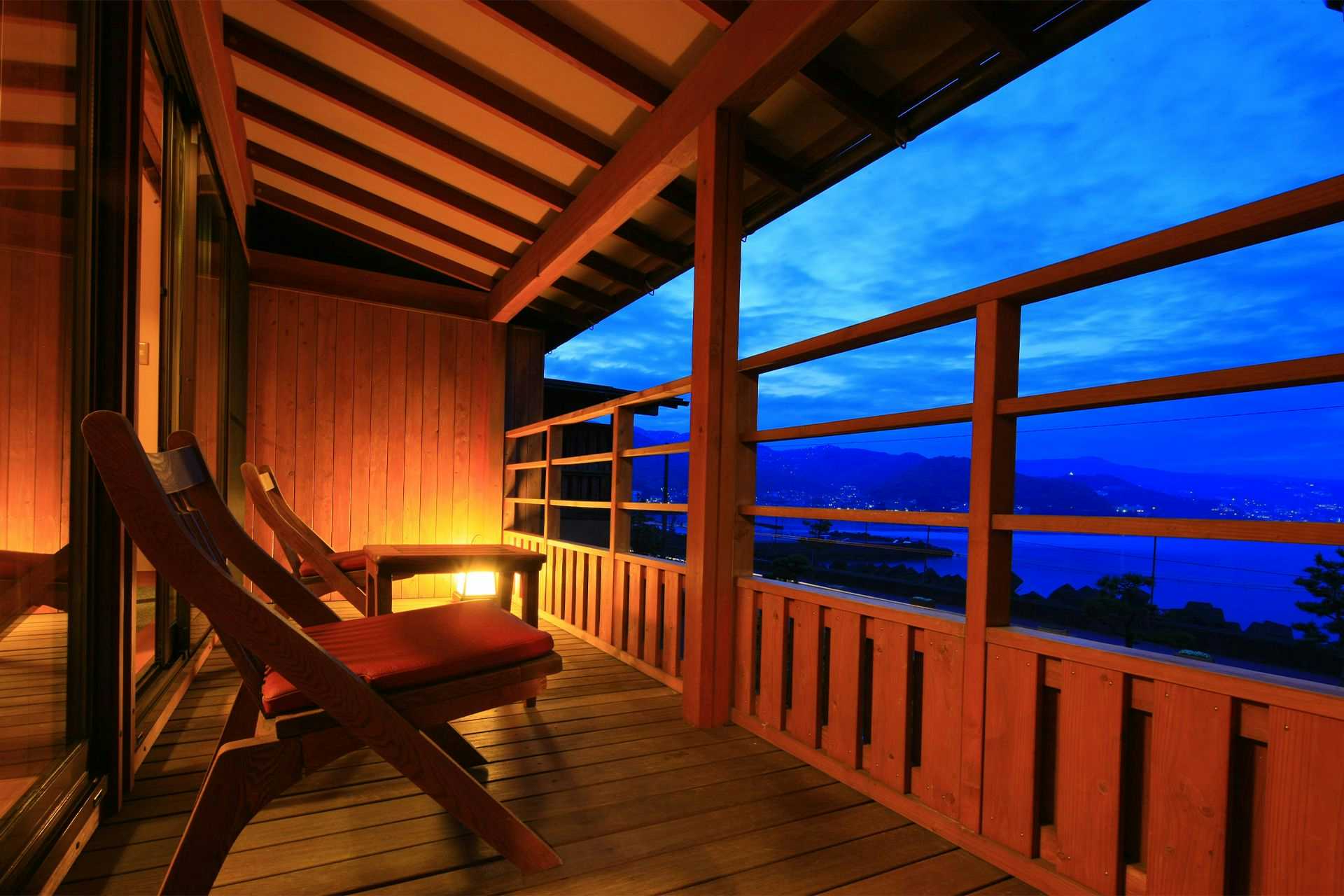 Gensen Yuyado Taiseikan (TAISEIKAN) with a covered timber terrace overlooking the blue coastline.