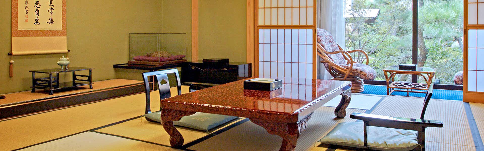 Shinshu Togura Kamiyamada Onsen Kihinkan Ryotei Takano Tatami sitting room with polished low table, floor chairs, raised alcove, paper screens, and garden-facing windows