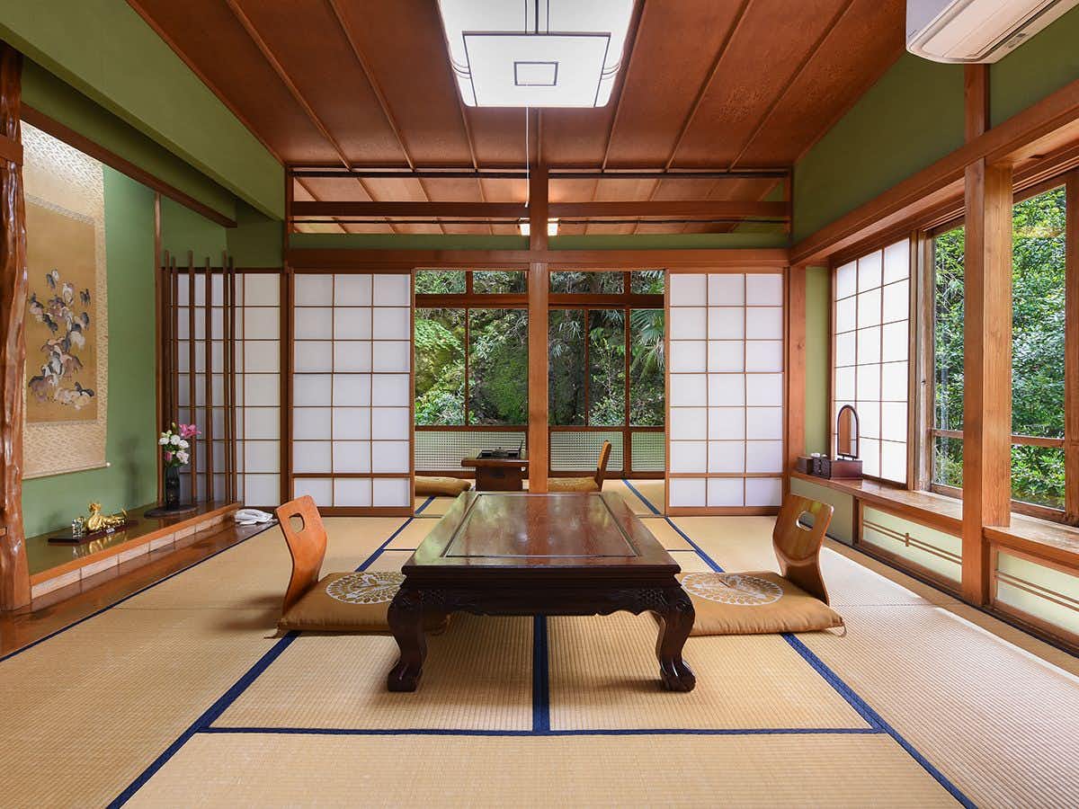 Manjuso Sawada Ryokan green-walled tatami room with a low table and forest-facing windows