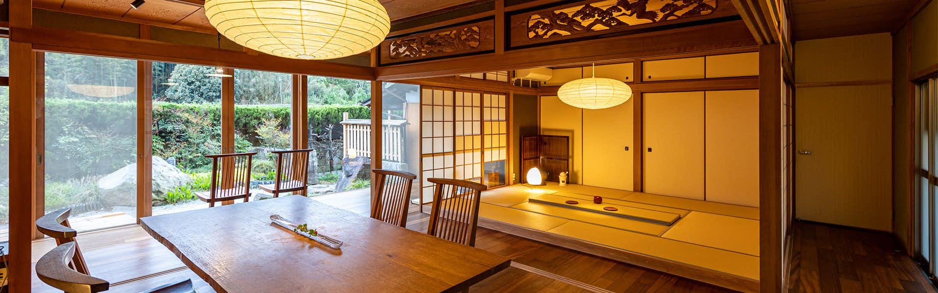 Oki Olive Guesthouse with a spacious tatami lounge opening toward broad garden windows.