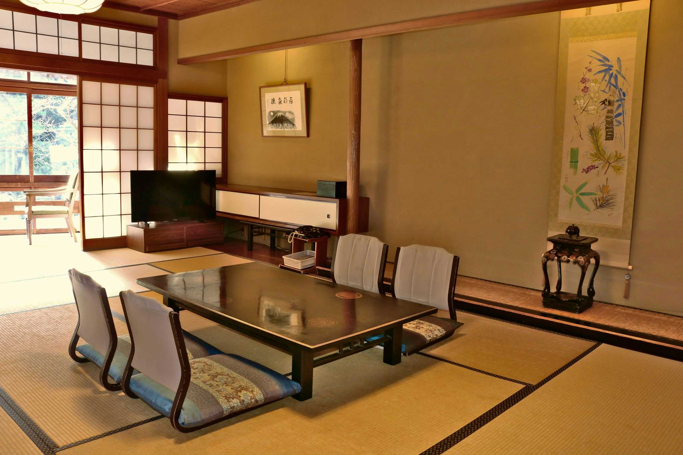 Kinosaki Onsen Tsutaya Ryokan with a formal tatami room with low table and painted alcove.