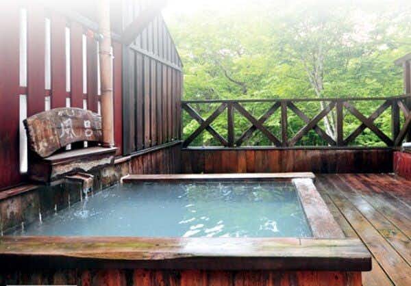 Shinyu Onsen Kurikoma-so with an outdoor square bath surrounded by green woodland.