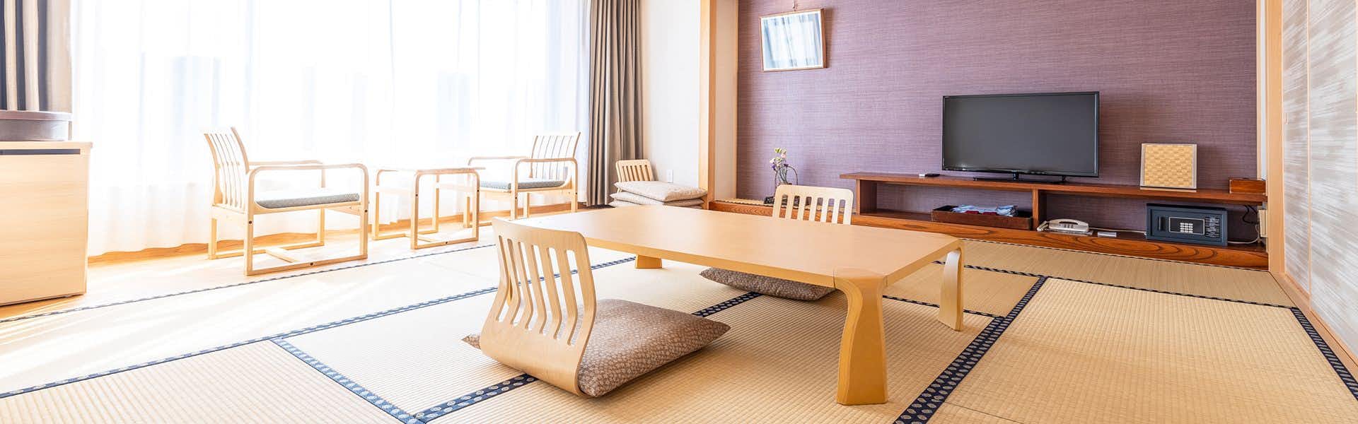 Sansuien, Natural Hot Spring at the Foot of Kochi Castle with a bright tatami room with low chairs and television.
