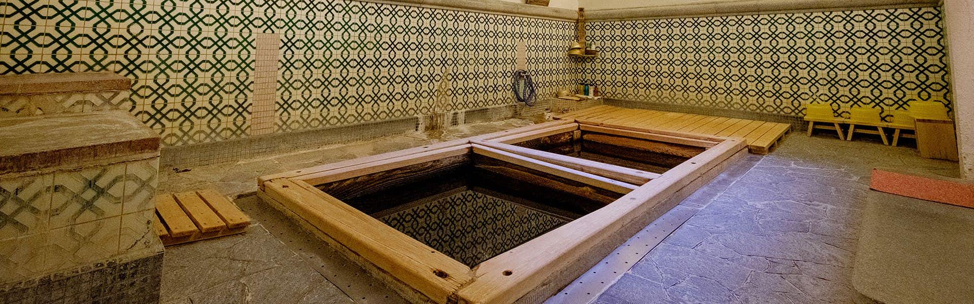 Kiya Ryokan, a Registered Tangible Cultural Property Inn with twin sunken wooden baths beneath patterned tile walls.