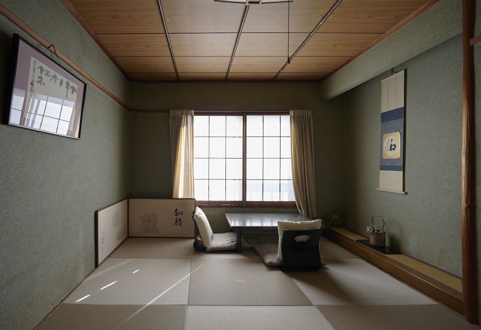 A simple room is arranged with low seating and shoji windows.
