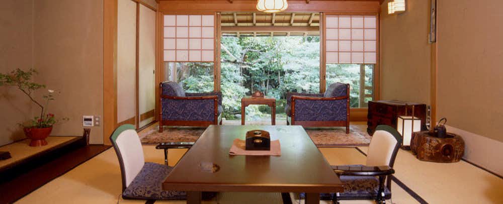 Kappo Ryokan Momiya with a refined tatami room overlooking a compact garden.