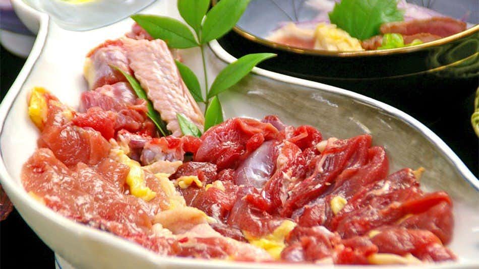 Ryokan Matsumoto-tei with thinly sliced red meat arranged with green leaves.