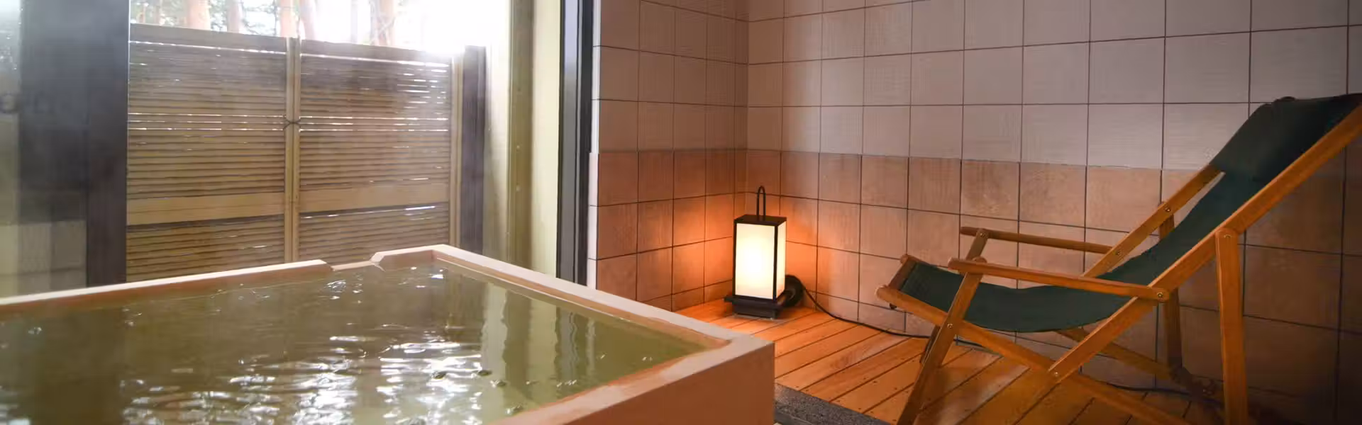 Hotel Yamabuki with this scene, where a compact guest-room bath is paired with a reclining chair behind glass.