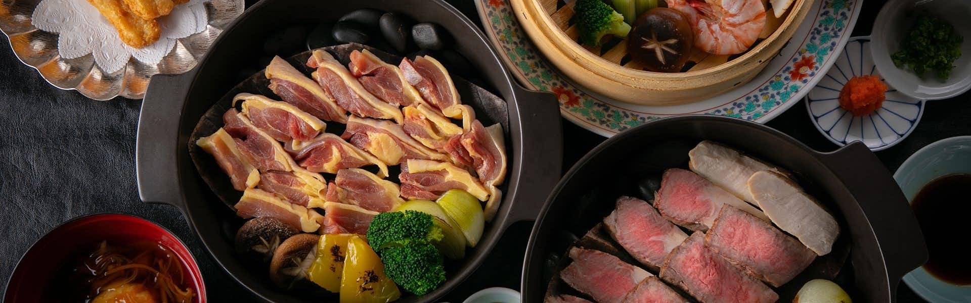 Yutaka no Go Saigakukan with a colorful Japanese dinner arranged in black ceramic bowls.