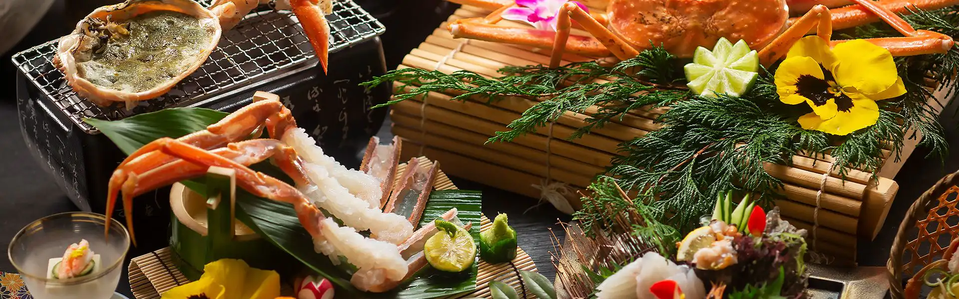Kawaguchiya Kinosaki Riverside Hotel with this scene, where its shellfish and crustacean legs rest over a tabletop grill.