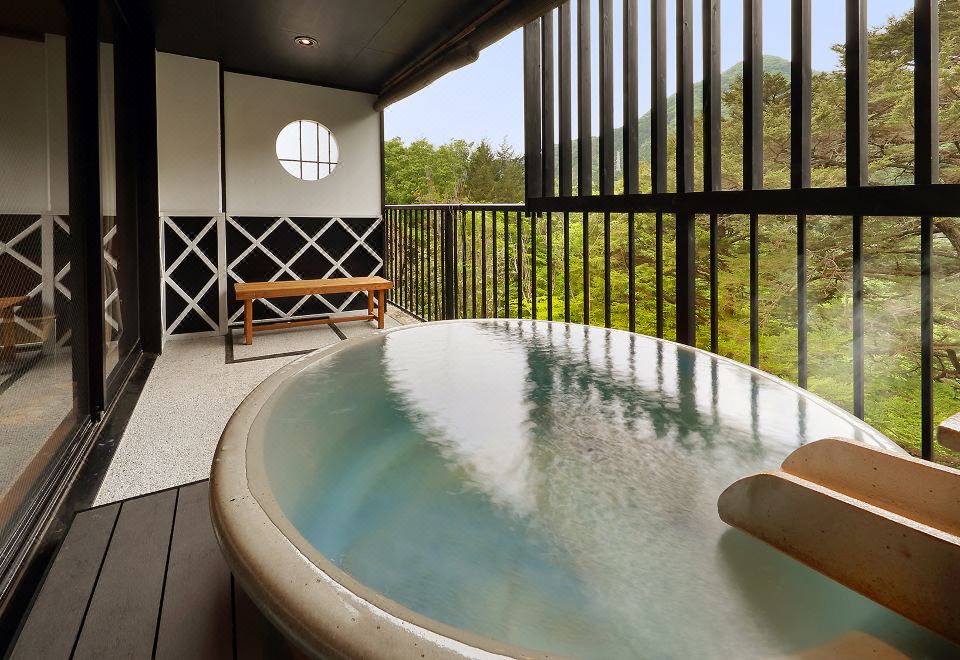 A private indoor bath beside a forest view.