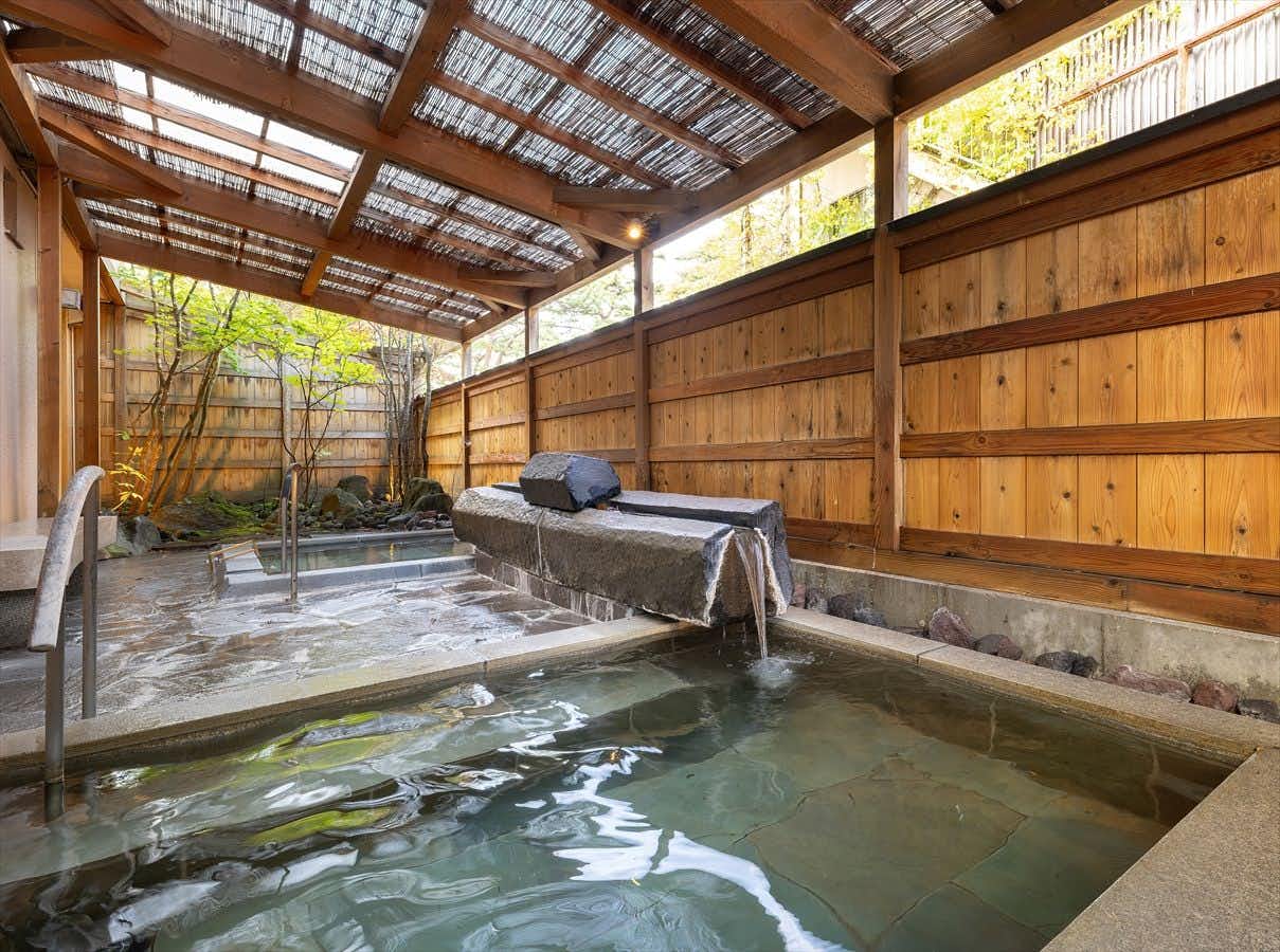 Katakuri no Hana: A sheltered outdoor bath enclosed by pale timber fencing.