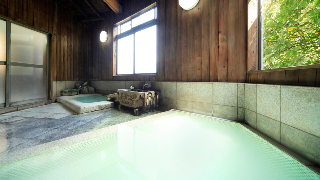 A second indoor bath is framed by windows and wood paneling.
