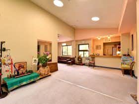 Futamata Onsen Kashiwaya Ryokan Interior space with wooden ceiling, beige walls, ceramic potted plants, wooden furniture, and recessed ceiling lights