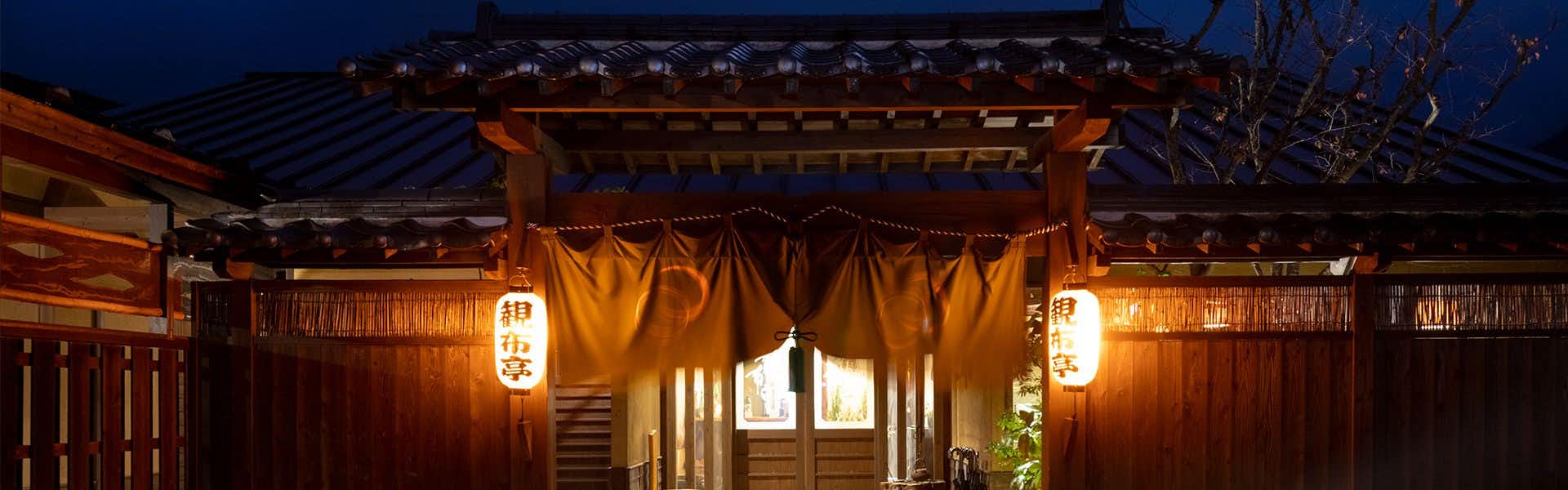 Iyashi no Sato Kanputei traditional wooden entrance gate illuminated at night