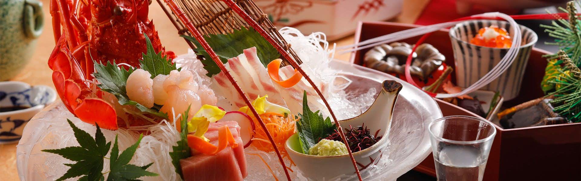 Hyoe Koyokaku Plated display with translucent items arranged on white dishes, red decorative fabric, green garnish sprigs, and small bowls with various contents.