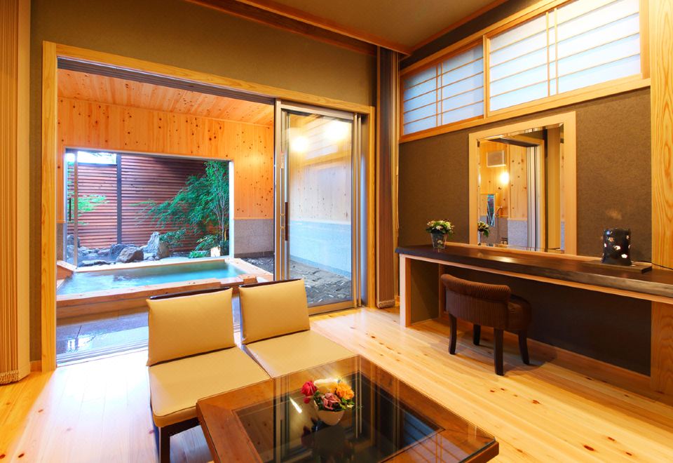 A Japanese room with chairs beside an open garden.