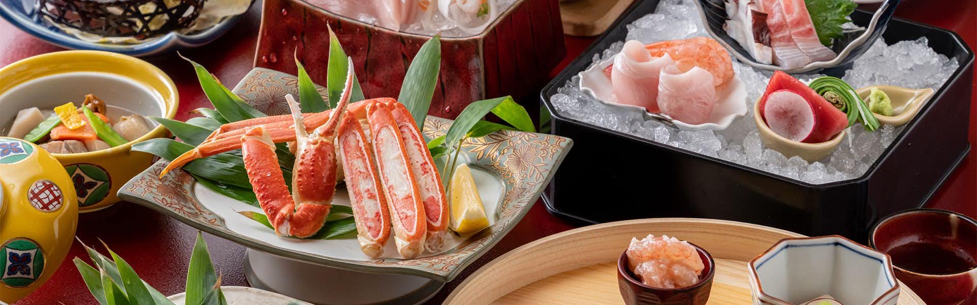 Niigata Iwamuro Onsen Private Hot Spring Inn Fujiya with a generous seafood dinner arranged across colorful ceramic dishes.