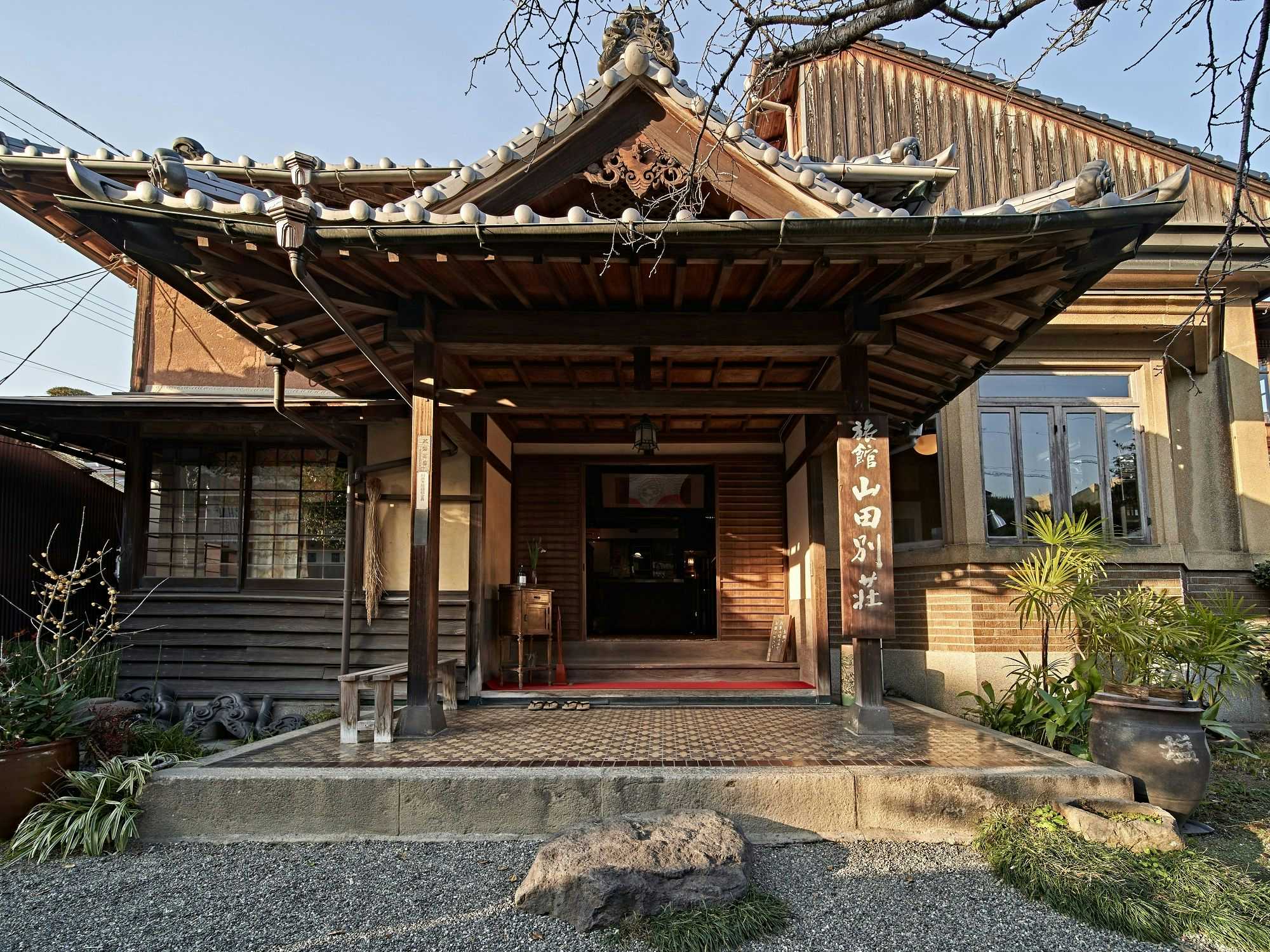 Yamada Bessou with a tiled entrance canopy opening toward a stone courtyard.
