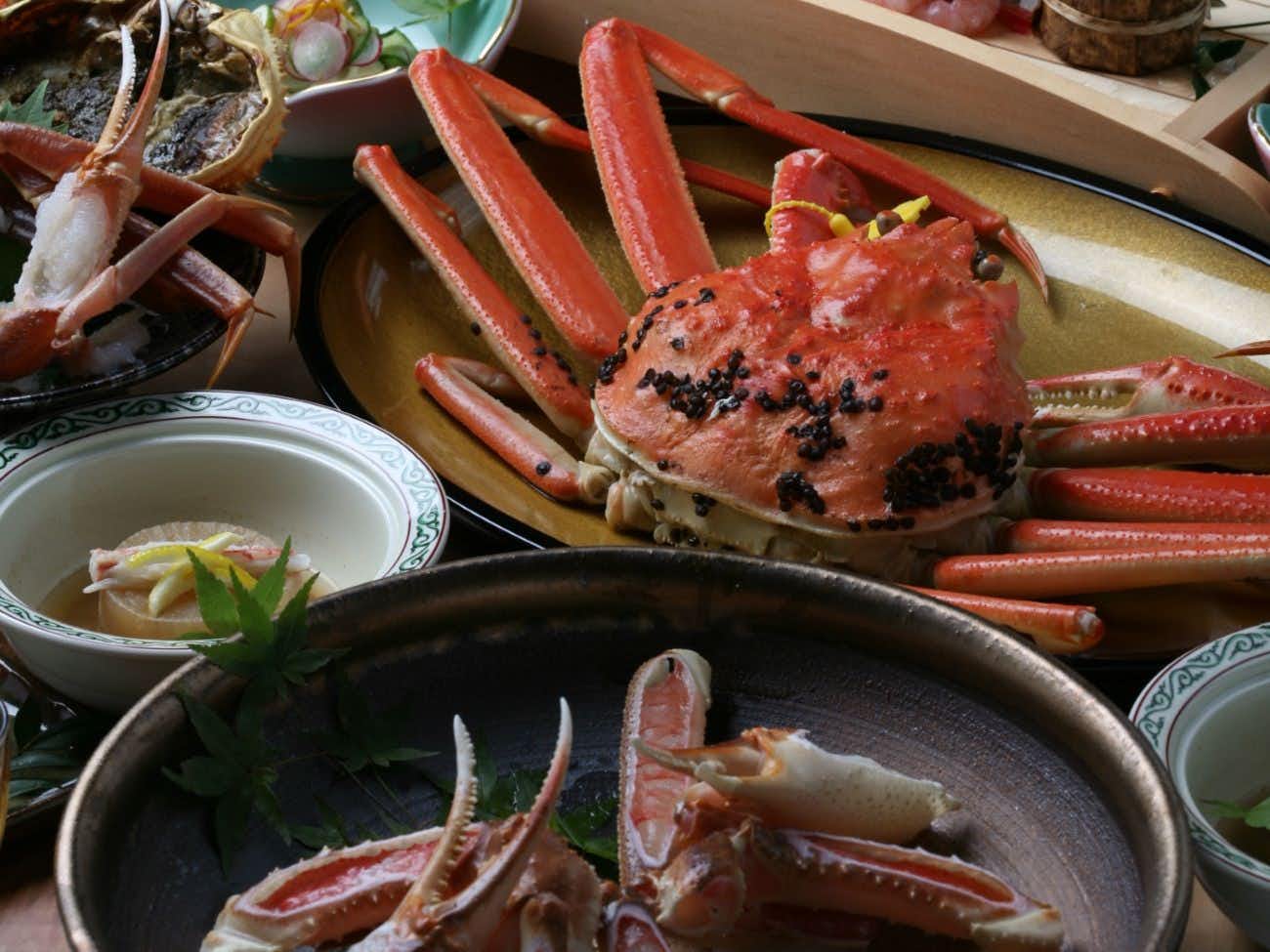 Annex Oyado Uotake with cooked crab arranged with broth and ceramic bowls.
