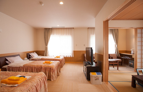 Twin-bed guest room adjoining a tatami sitting area.