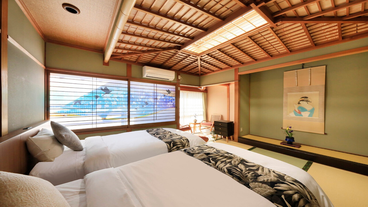 Tatami guest room with twin beds and a low table.