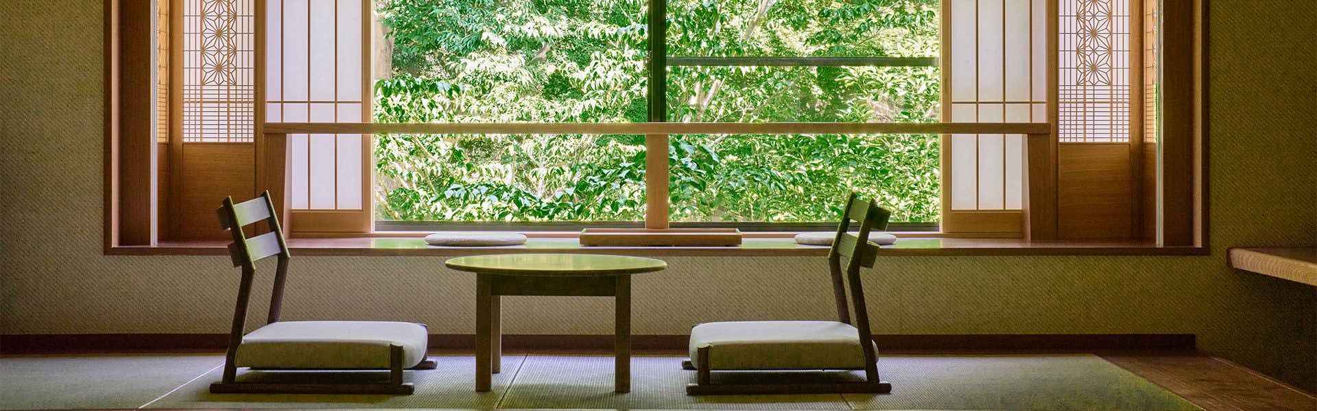 Ryokan Suuntei with a serene tatami sitting room overlooking leafy woodland.