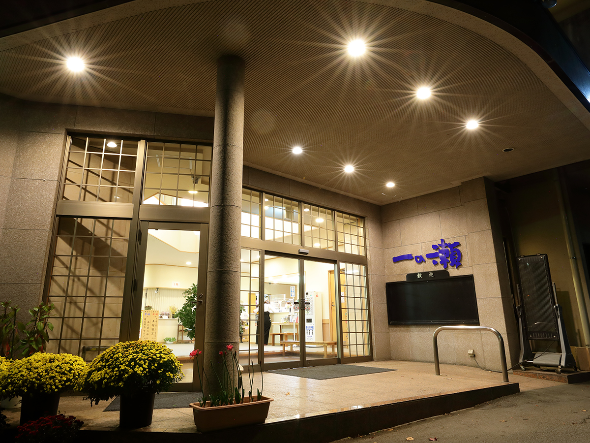 Ichinose with the modern entrance beneath bright circular canopy lights.