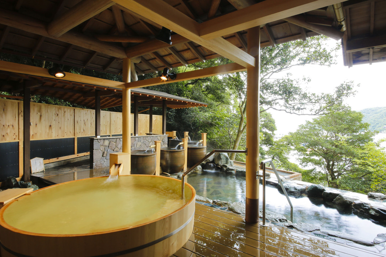 Covered outdoor bath set among trees.