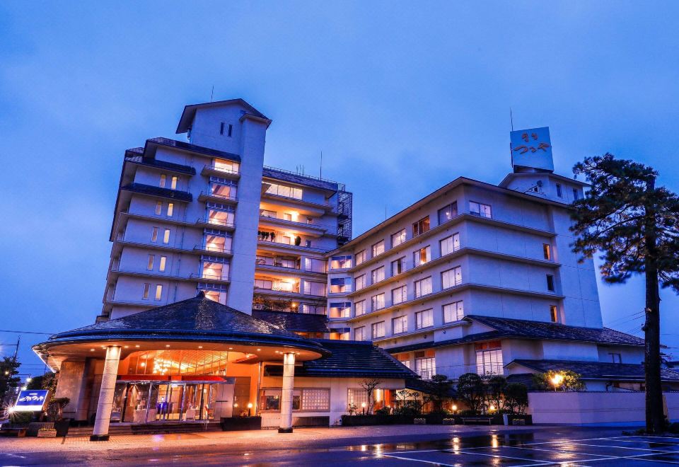 A multi-story hotel building lit at dusk.