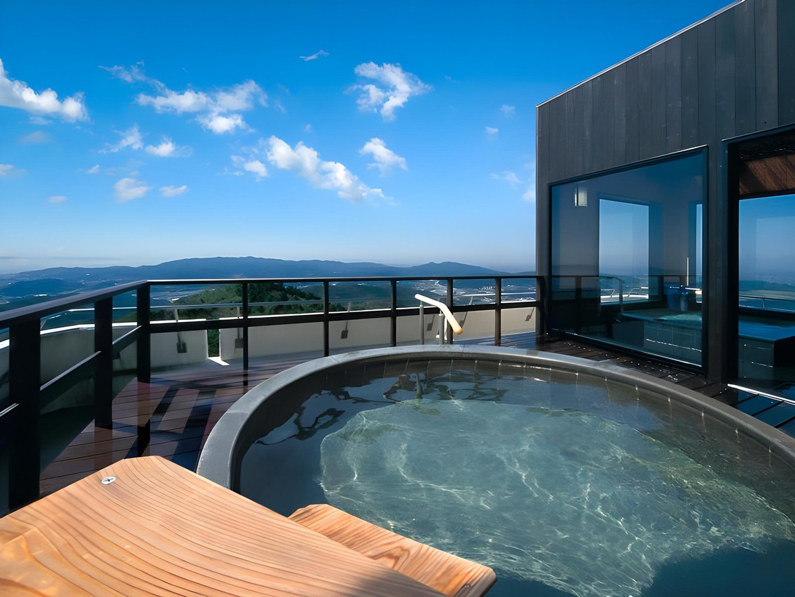 A rooftop bath overlooks the blue sea and horizon.