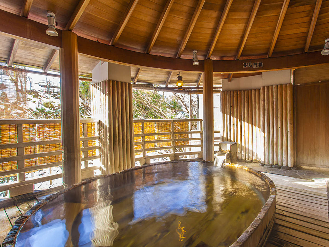 Indoor bath beside a wooden screen.
