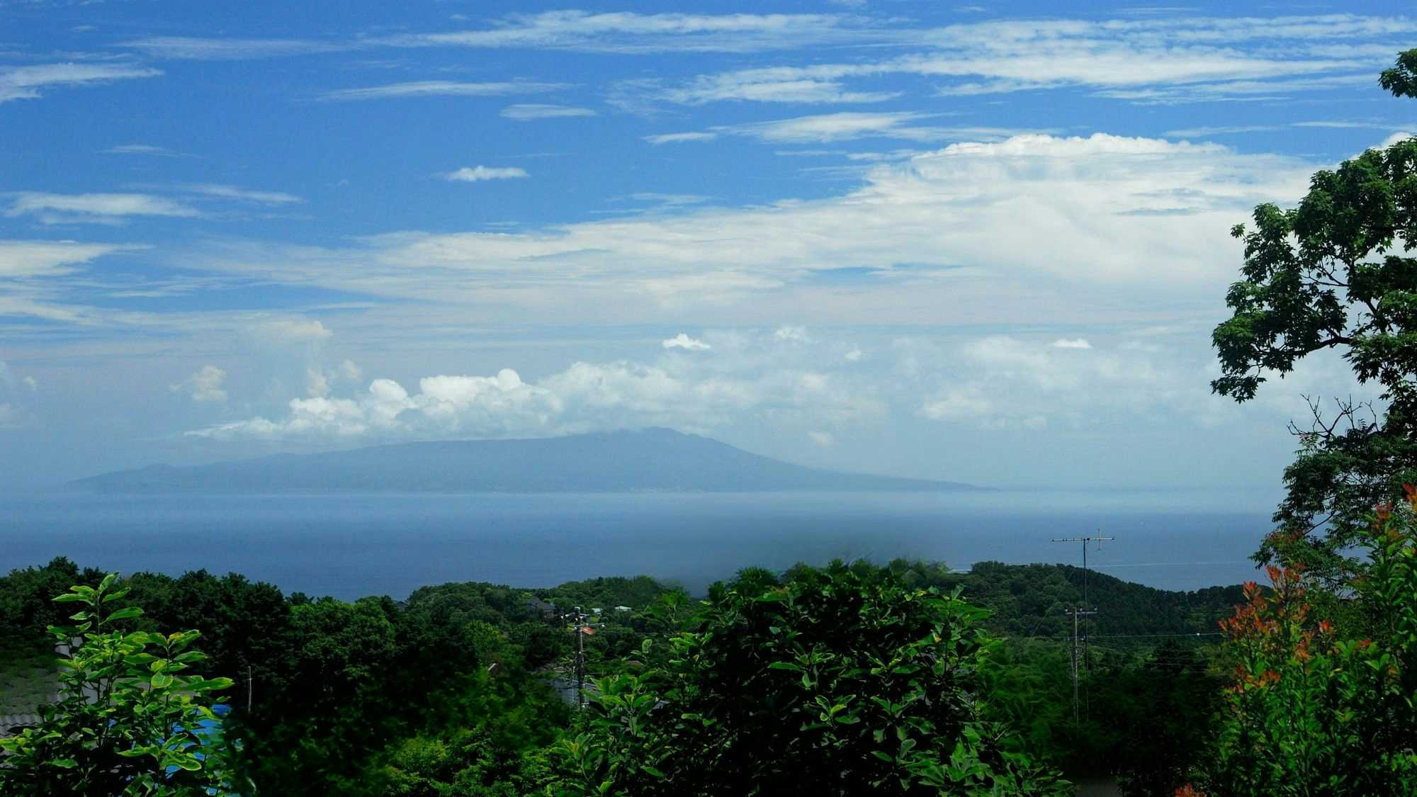 Nipponia Kogen Yado Yume Mizuki with a distant ocean view beneath layered blue clouds.