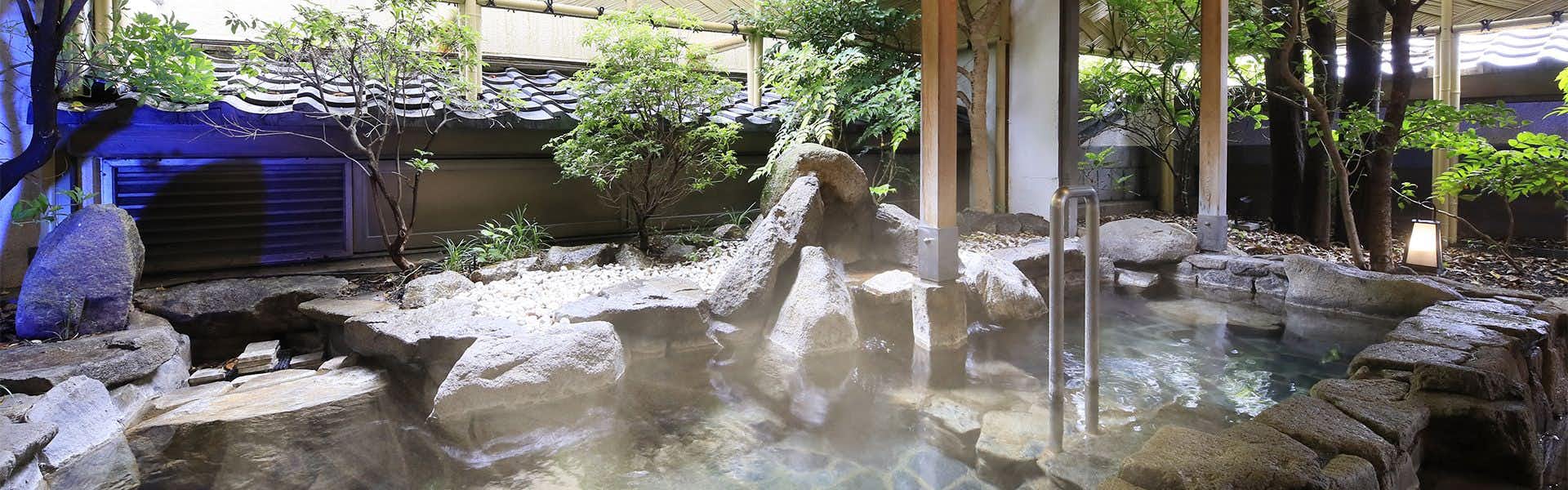 Kamisuwa Onsen Hamanoyu: An open-air stone bath surrounded by a landscaped garden.