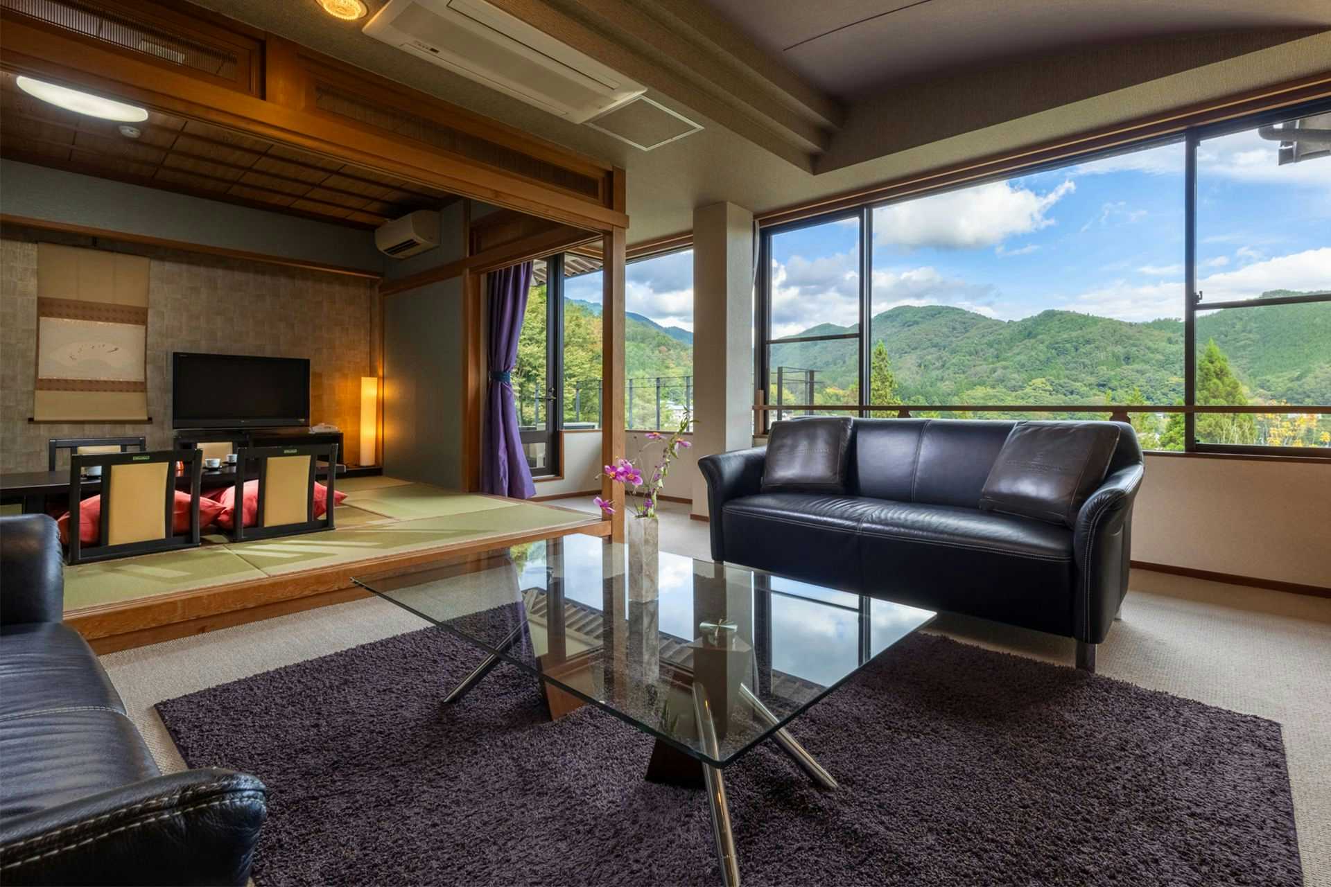 Hirugami Onsen Shiki no Ori Hanaya with a modern suite with black leather sofa and mountain windows.