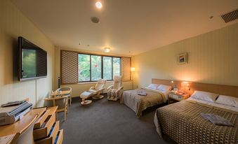 Carpeted guest room with multiple single beds, a television, seating, and wide windows.