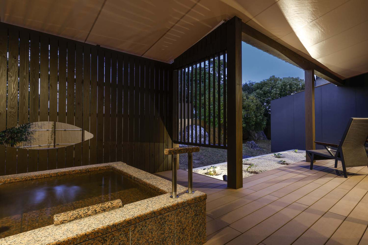 An outdoor bath beside a covered terrace.
