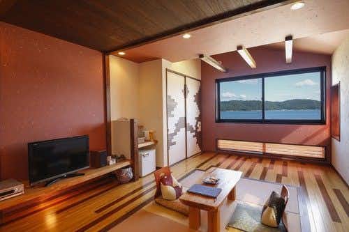 Yoka no Yado Hanashobu with a modern timber guest room with low table and waterfront window.