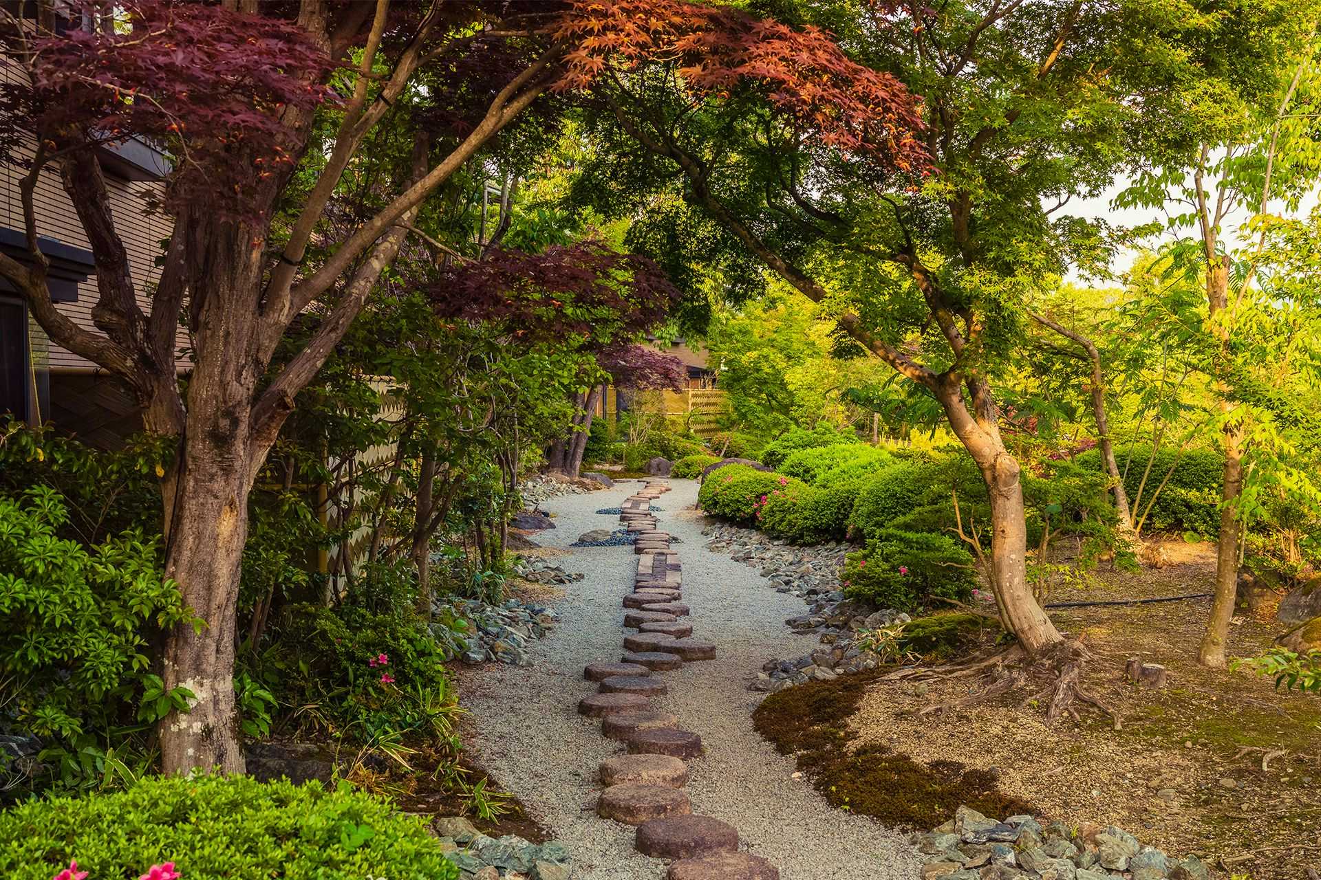 Ryokan Suuntei with a winding stone garden path beneath maple trees.