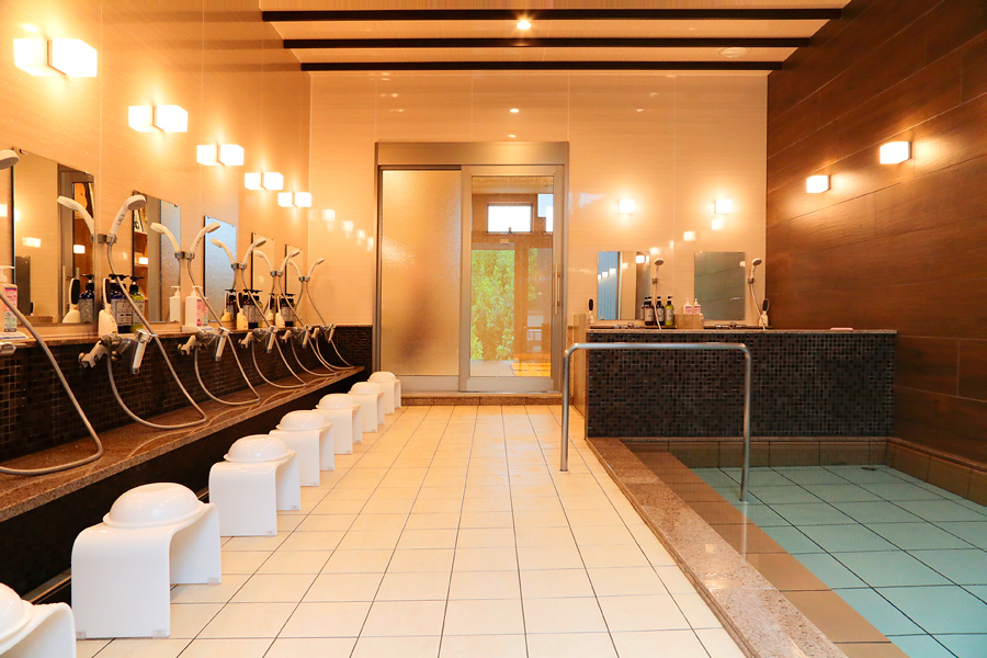 An orderly communal washing area and indoor bath entrance.