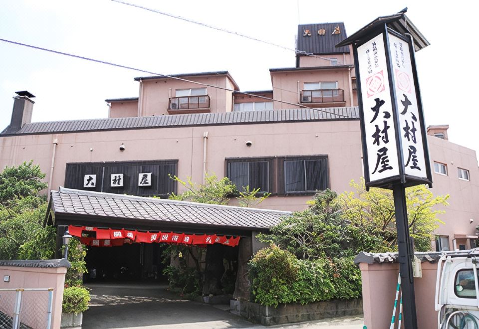 Exterior entrance with a tall illuminated sign.