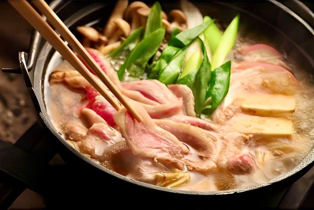 Sansuikan Shinano with thinly sliced meat cooking with vegetables in a hot pot.