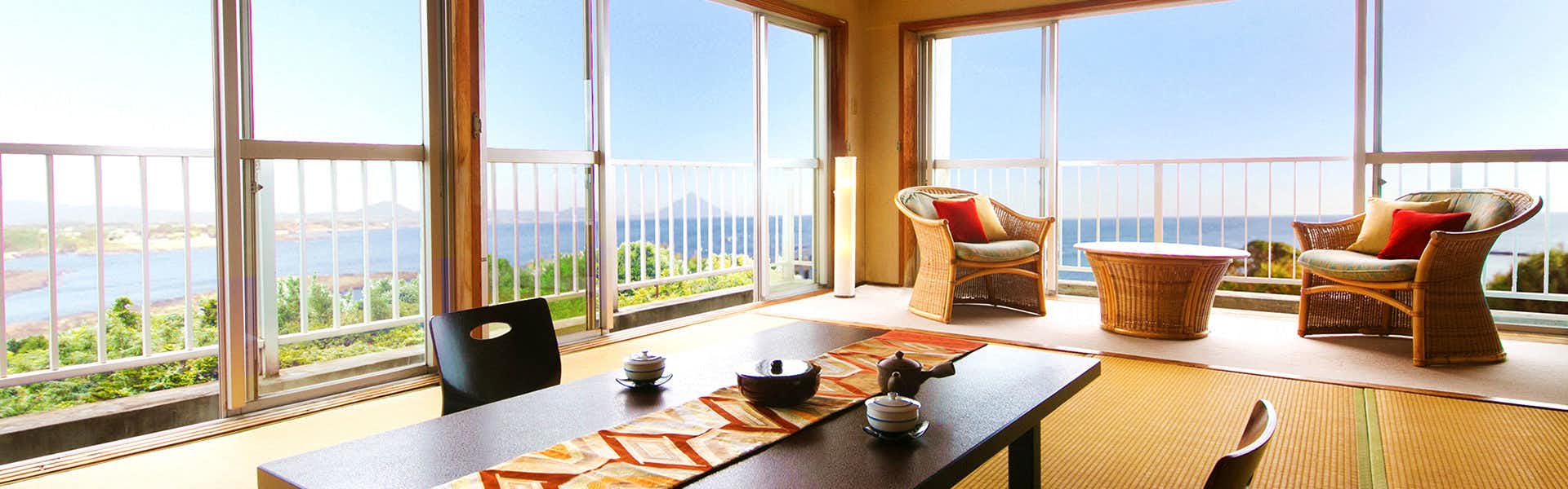 Iseebi Inn with a bright tatami room facing the blue ocean through wide windows.