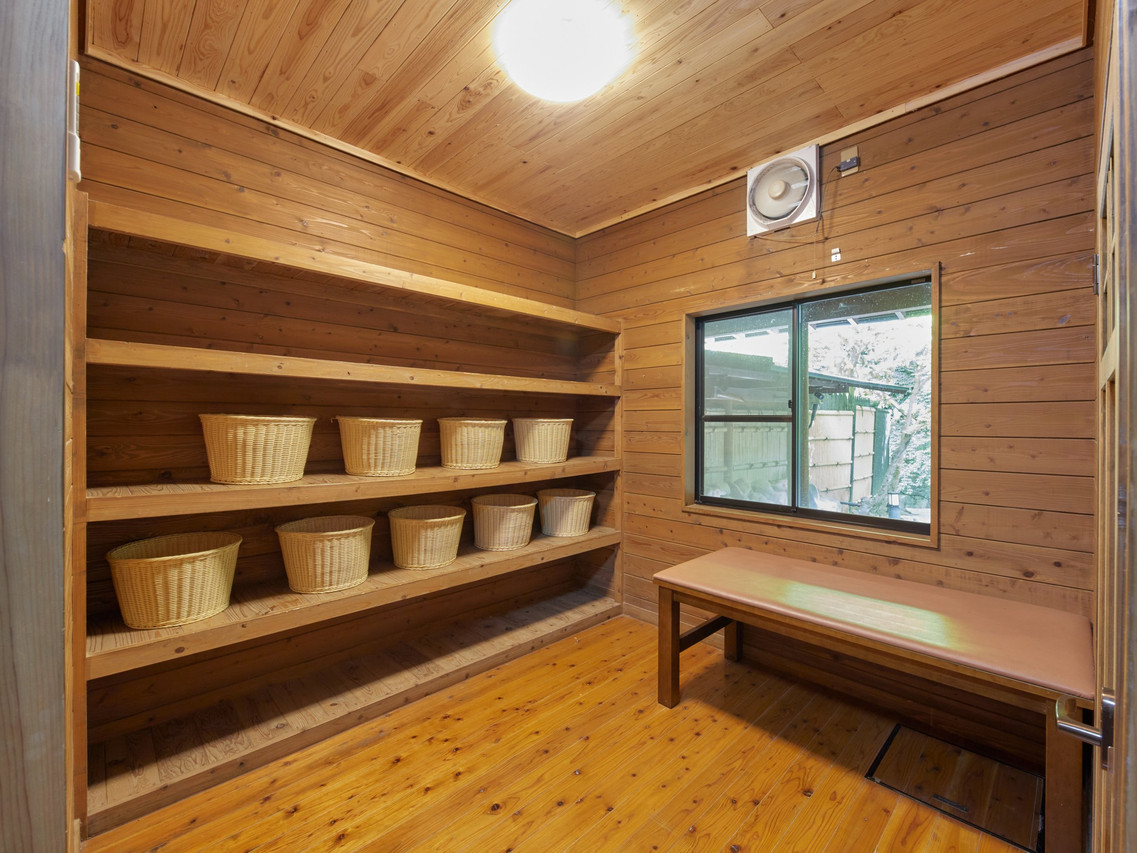 A wood-paneled room contains open shelving and a small table.