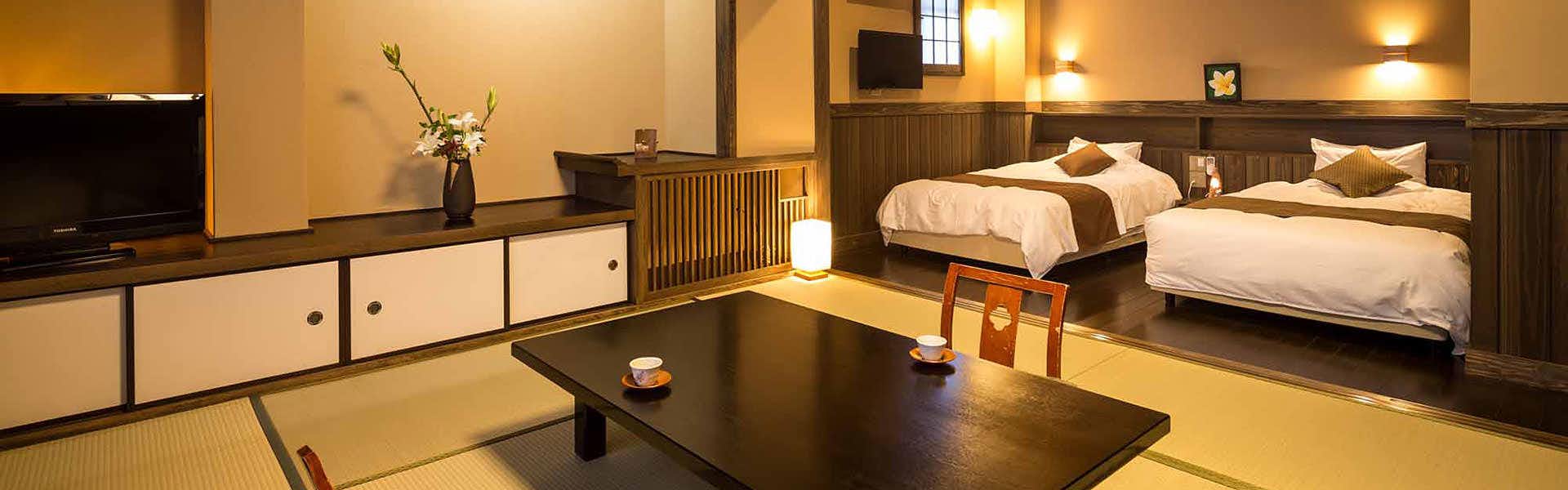Ryokan Wakaba a guest room combining twin beds with a tatami sitting area.